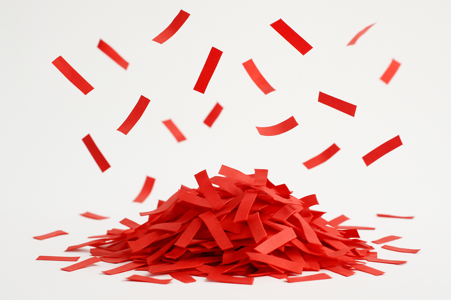 red confetti strips in a pile with some floating