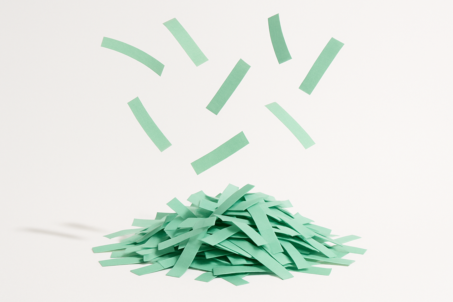 mint green confetti strips in a pile with some floating